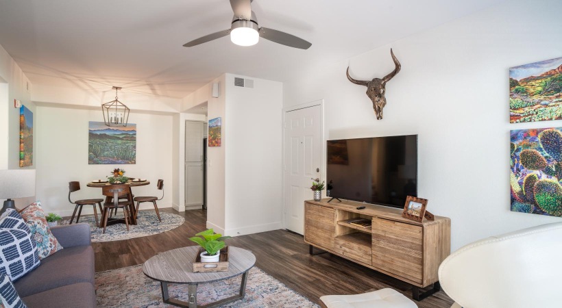 a living room with a ceiling fan and a table